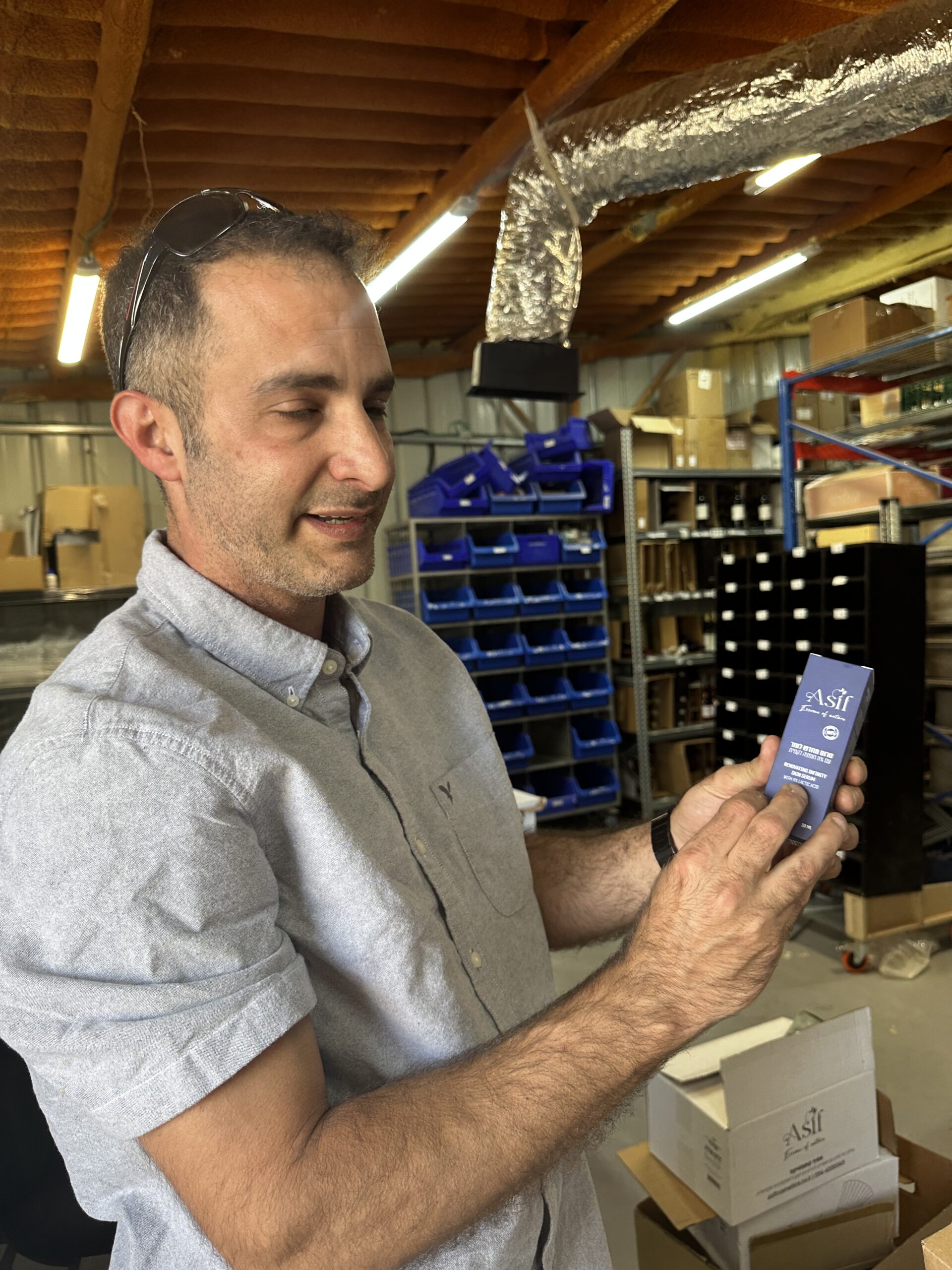 Tzvika Zamir holding an Asif serum in his workshop